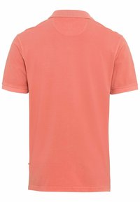 Kortærmet polo-shirt i koralfarve, lavet af bomuld. Har en klassisk krave og et minimalistisk design med en ensartet tekstur.