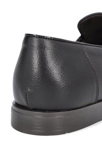 Czarne skórzane buty o gładkiej fakturze, zaokrąglonym obcasie i gumowej podeszwie. Posiadają proste przeszycia i niski profil.