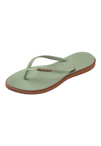 Sandale tongs en caoutchouc verte et marron avec semelle texturée et fines lanières arborant un petit logo métallique "Havaianas".