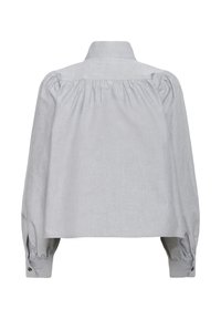 Lys grå langærmet skjorte med pufskuldre, ryg yoke-pleats, knapmanchetter og ståkrave, vist fra ryggen.