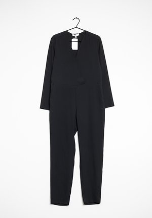 Combinaison noire à manches longues, décolleté en V profond et deux poches latérales. Fabriquée en tissu lisse, avec une silhouette ajustée et un design sans coutures.