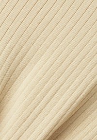 Tissu en tricot côtelé beige clair avec des rayures verticales en relief. Texture douce, matériau de poids moyen, adapté aux vêtements décontractés ou aux accessoires.