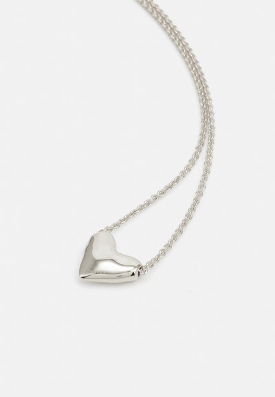 Collar con colgante de corazón plateado con un acabado pulido, suspendido de una delicada cadena de eslabones retorcidos.