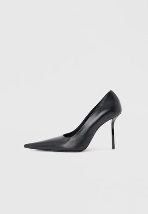 Black leather high-heeled pump with pointed toe and slim stiletto heel on white background.