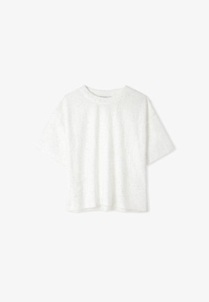 T-shirt bianco a maniche corte realizzato in tessuto testurizzato con piccoli e irregolari motivi a puntini. Collo rotondo, vestibilità ampia e orlo dritto.