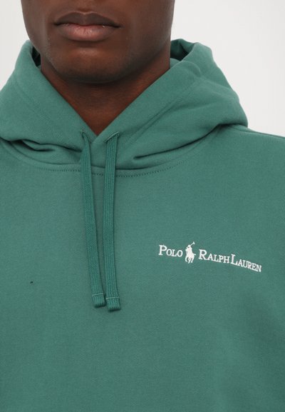 Roheline kapuutsiga sviiter pehmest kangast, millel on nööriga kapuuts ja valge "Polo Ralph Lauren" logo rinnal. Lihtne disain, lõdvestunud stiil.