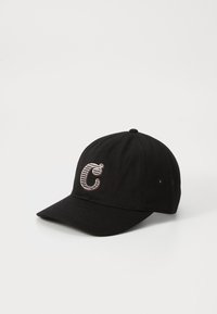Čierna baseballová čiapka s zakriveným okrajom, vyrobená z textúrovanej tkaniny, obsahuje výrazne vyšívané písmeno "C" v pruhovanom dizajne.