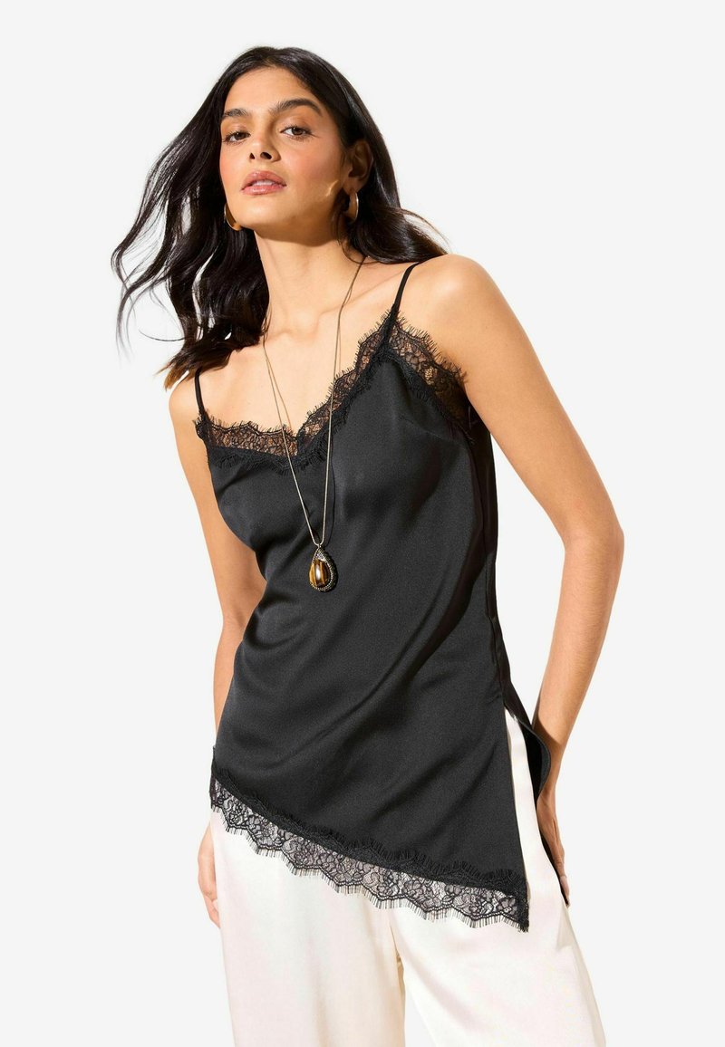 Camiseta de satén negro con ribete de encaje a lo largo del escote y el dobladillo, con tirantes de espagueti ajustables y una abertura lateral para más detalle.