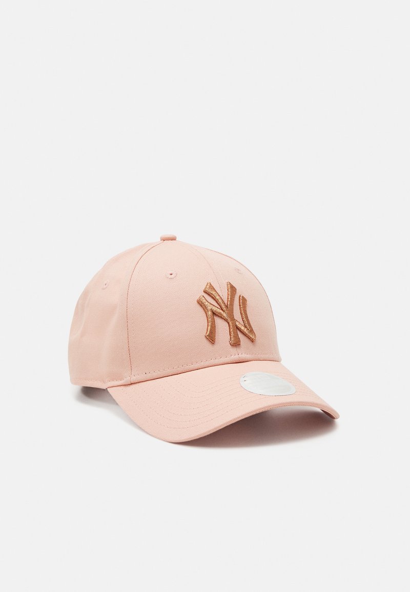 Casquette de base-ball rose avec une visière incurvée, ornée d'un logo doré brodé en relief à l'avant et d'un autocollant blanc circulaire sur la visière.