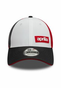 Gorra de béisbol blanca y negra con acentos rojos, presenta el logo "aprilia" en un parche, con ajuste trasero y visera curva. Estilo New Era 9FORTY.
