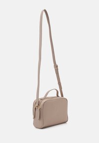 Beżowa torba na ramię o fakturowanym wykończeniu, prostokątnym kształcie, podwójnych zamykanych na zamek komorach oraz regulowanym pasku do wszechstronnego noszenia.