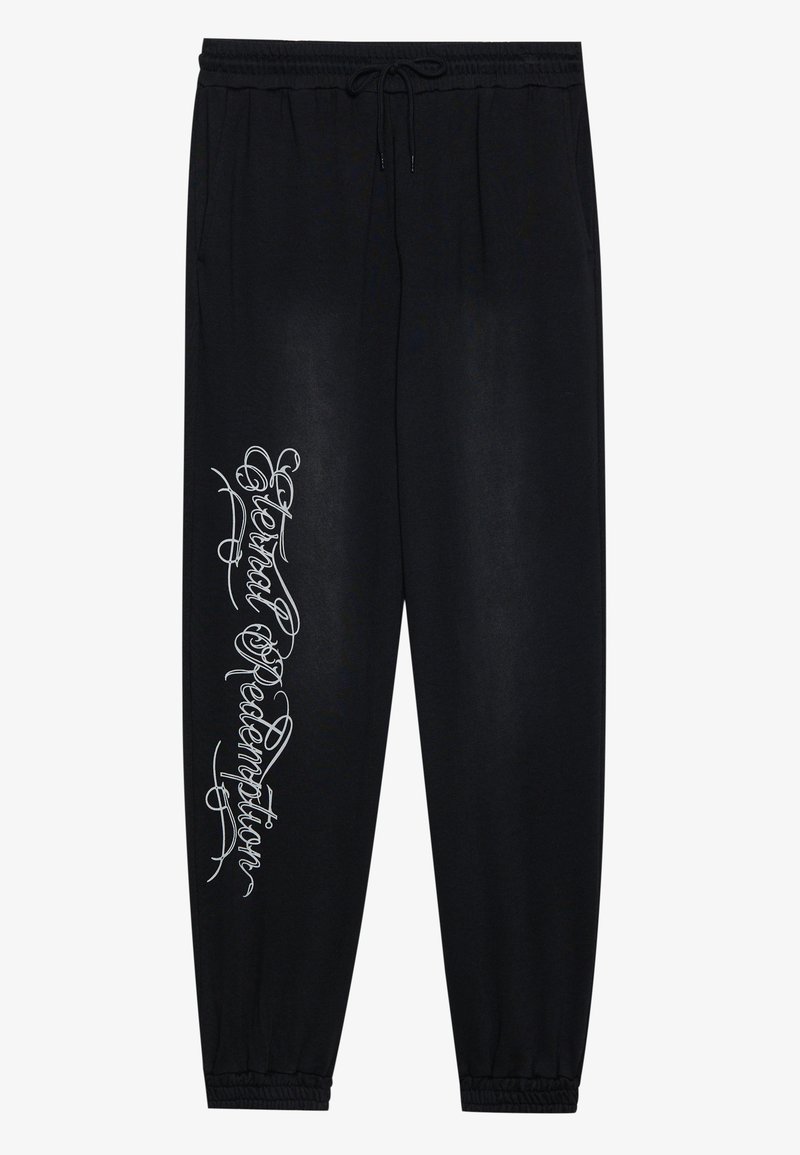 Schwarze Jogginghose mit einem elastischen Bund, Seitentaschen und einem silbernen grafiktextlichen Design am linken Bein. Weicher Stoff mit glatter Textur.