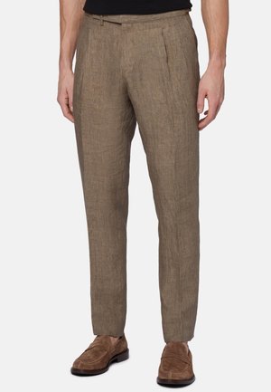 Broek in een gestructureerde lichtbruine stof, met een rechte pasvorm, enkele plooi en riemlussen, gecombineerd met bruine instapschoenen.
