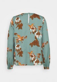 Blouse à manches longues bleu sarcelle avec un dos à œillet boutonné, décorée d'oiseaux orange et de motifs floraux marron et blancs.
