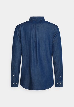 Chemise en jean à manches longues vue de dos avec poignets boutonnés et un petit bouton au col en tissu bleu foncé.