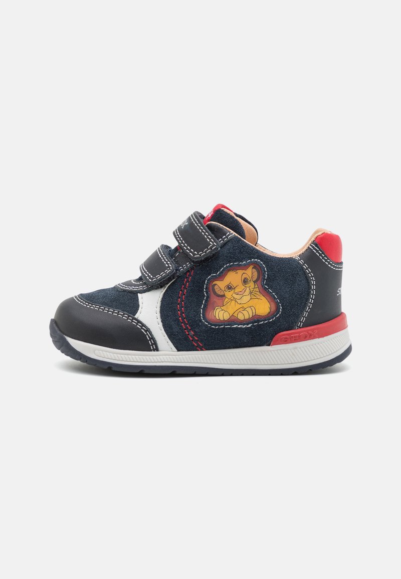 Navy suede kindersneaker met klittenbandsluiting, met witte en rode accenten, featuring een leeuwengrafiek op de zijkant en een textuur rubberen zool.
