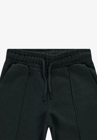 Zwarte joggingbroek met een elastische tailleband, trekkoord en naden aan de zijkant. Gemaakt van zachte, gestructureerde stof.