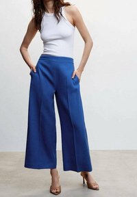 Wijde broekspijpen in levendig blauw, vervaardigd uit een stevige stof. Heeft een hoge taille met zijzakken en een gladde textuur.