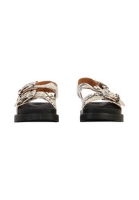 Sandales à bout ouvert avec semelles noires et brides à motif serpent, ornées de boucles argentées, vues de face sur un fond blanc.