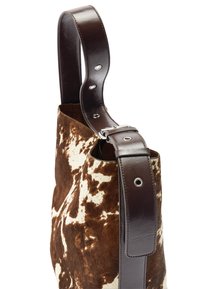 Brązowa i biała torba ze skóry bydlęcej z ciemnobrązowym paskiem ze skóry, wyposażona w srebrne okucia i teksturowane wykończenie.