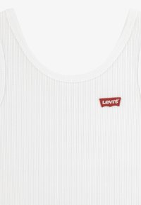 Canotta bianca a coste con scollo rotondo. Presenta una piccola patch con logo Levi's rosso sulla parte anteriore. Texture morbida e design aderente.