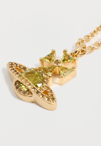 Arany medál sárgászöld drágakövekkel, bolygó alakú gyűrűkkel és kereszt alakú díszítéssel, finom láncon.