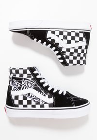 Černobílé tenisky s vysokým svrškem s motivem šachovnice, vyrobené z semiše a plátna, s bílými tkaničkami a značkou Vans.