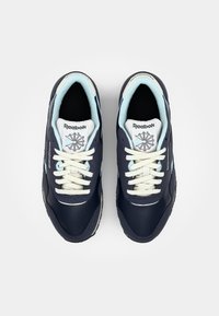 Marina blå Reebok sneakers har en slät yta, ljusblå detaljer, vita snören och en texturerad sula för grepp, med logotypdetaljer på tungan.