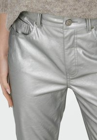 Zilveren neplederen broek met een gladde, glanzende textuur, voorzien van steekzakken en een metalen knoopsluiting.