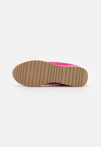 Rosa sneakers med en teksturert semsket overdel og en fleksibel gummisåle. Sålen har horisontale riller for godt grep.