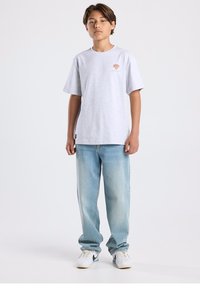 Gray short-sleeve t-shirt with a colorful graphic design, paired with light blue loose-fit jeans and white sneakers featuring a black accent.