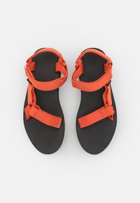 Svarta sandaler med orange remmar, som har en texturerad innersula och justerbara spännen, designade för komfort och utomhusbruk.