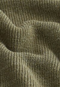 Gestructureerde olijfgroene brei stof met zichtbare ribbetjes. Zachte, licht pluizige textuur met een lichte kleurvariatie overal.