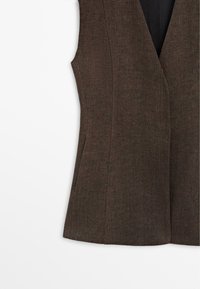Bruin mouwloos vest met getailleerde naden en zijzakken met openingen, gemaakt van gestructureerde stof.
