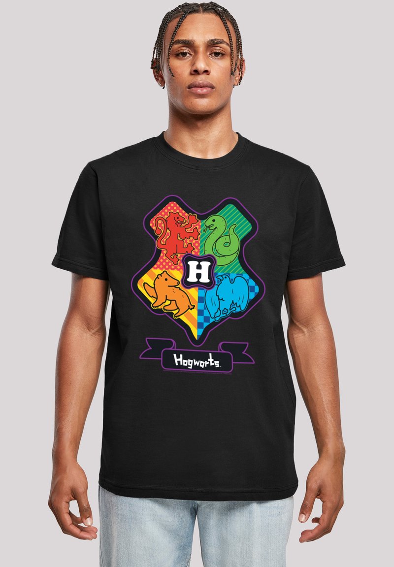 Svart t-shirt med en färgglad design av Hogwarts-vapnet som har husdjur: lejon, orm, grävling och örn, centrerat med texten "Hogwarts" nedanför.