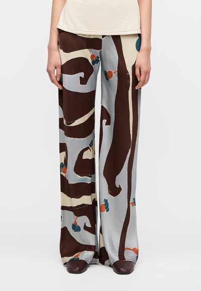 Vide bukser i et lett, silkeaktig stoff med et virvlende mønster i brun, lyseblått og innslag av blågrønt og oransje.