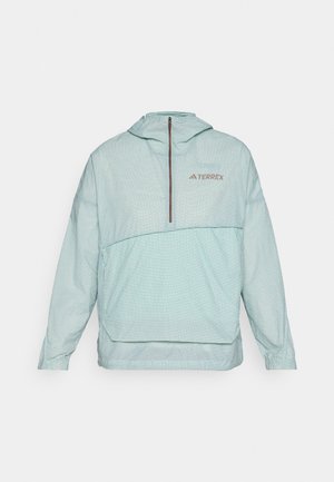 Hellgrüner, gefütterter Windbreaker mit Karomuster, halber Reißverschluss vorne, elastischen Bündchen und einem Logo auf der Brust. Glatte Textur, leichtes Design.