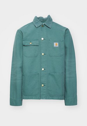 Türkise Baumwolljacke mit Kragen, vorderem Knopfverschluss, zwei Brusttaschen und einem linken Logo-Aufnäher. Glatte Textur und lässiges Design.