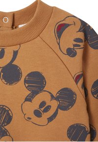 Hellbraun sweatshirt mit blauen Mickey Mouse Druck. Verfügt über einen strukturierten runden Halsausschnitt und Raglanärmel, hergestellt aus weichem Baumwollstoff.