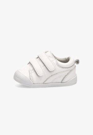 Zapatilla blanca para niño pequeño con dos tiras de velcro, puntera texturizada, cuello acolchado y lengüeta en un fondo blanco.
