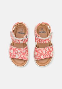 Rosa sandaler med blomstertryck och breda remmar; justerbara kardborreknäppningar, mjuk tanfärgad fotbädd och vita gummisulor.