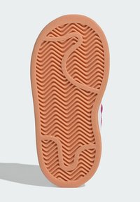 Podešev z gumy s vlnitým vzorem v broskvové barvě. Hladký povrch s zakřivenými drážkami pro lepší přilnavost a trakci.