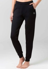 Sorte joggebukser med en tapered fit, elastisk talje, sidelommer og diskret logodetail. Fremstillet af blødt stof med en glat overflade.