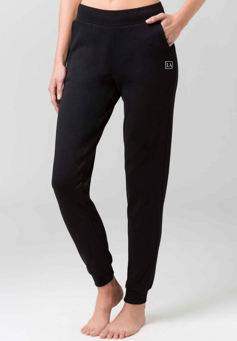 Sorte joggebukser med en tapered fit, elastisk talje, sidelommer og diskret logodetail. Fremstillet af blødt stof med en glat overflade.