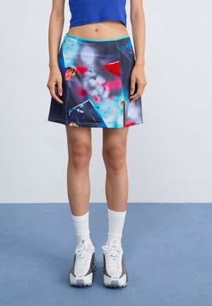 Kleurvolle, knie-lange rok met een grafische print in blauw, rood en grijs tinten. Inclusief contrasterende turkooizen tailleband en gestikte naden.