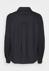 Chemise noire à manches longues avec un col classique, un pli dans le dos et des poignets boutonnés. Fabriquée dans un tissu lisse sans motifs visibles.