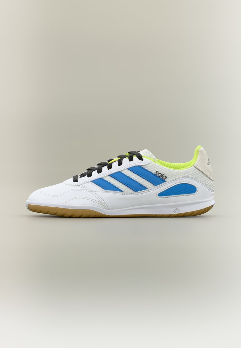 Baskets blanches de sport avec accents bleus et noirs, cuir texturé, semelle en caoutchouc et col rembourré. Présentent un design à trois bandes.