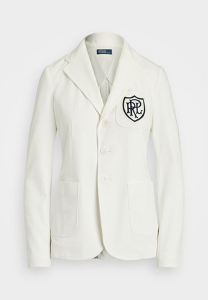 White cotton blazer with a notched lapel, three buttons, and two front pockets. Features an embroidered navy logo patch on the chest.