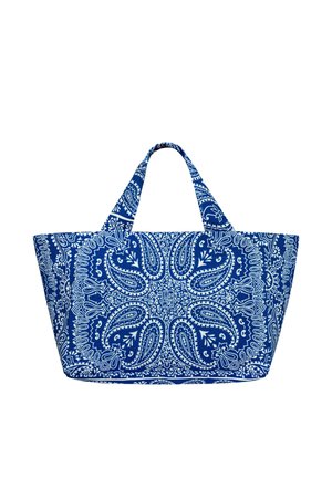 Torba na ramię z niebiesko-białej tkaniny z wzorami paisley i kwiatowymi, dwoma krótkimi uchwytami, szerokim trapezowatym kształtem i skomplikowanym, symetrycznym wzorem.