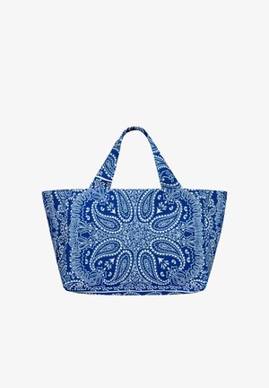 Torba na ramię z niebiesko-białej tkaniny z wzorami paisley i kwiatowymi, dwoma krótkimi uchwytami, szerokim trapezowatym kształtem i skomplikowanym, symetrycznym wzorem.